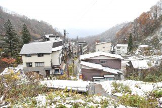 1面：温泉街が雪化粧　妙高市の山沿いで今季初の積雪観測
